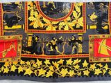 a close up of a black and yellow scarf with a picture of a man on a horse