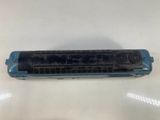 a close up of a blue harmonica on a white table