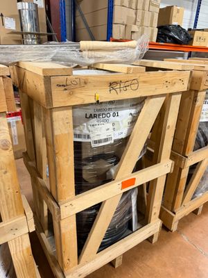 many pallets of drums in a warehouse with pallets on the floor