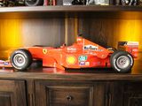 une maquette de voiture de course posée sur une étagère en bois