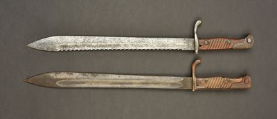 two knives are sitting side by side on a gray surface