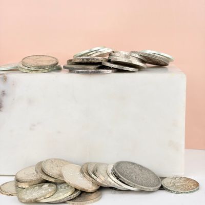 marble block with a pile of coins sitting on top of it