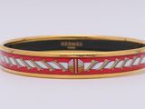 un gros plan d'un bracelet rouge et blanc posé sur une surface blanche