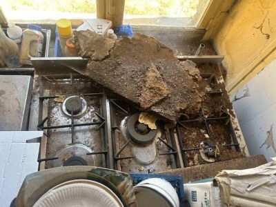 a pile of dirty dishes on the stove in the kitchen