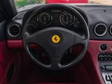the interior of a red sports car with a steering wheel and dashboard