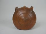 un petit vase marron orné de deux cornes