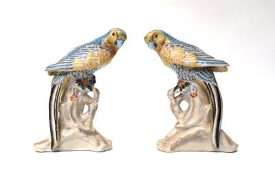 two figurines of birds sitting on a tree branch