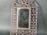 an old metal mirror with a decorative design on the outside of it