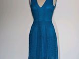 une robe bleue posée sur un mannequin, sur fond blanc