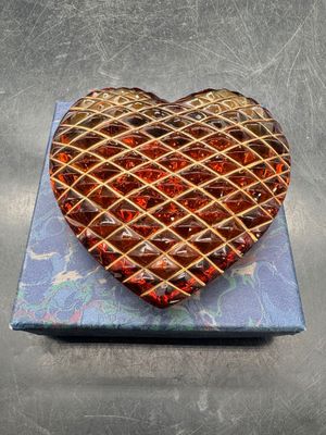 un gâteau en forme de cœur posé sur une assiette bleue, sur une table