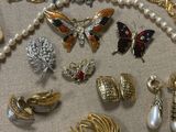 many different types of jewelry on display on a table