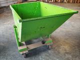 a green dumpster sitting in the middle of a room