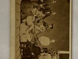 an old photo of a group of people sitting around a table