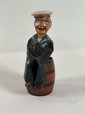 a figurine of a man sitting on top of a barrel