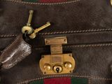 a close up of a brown leather bag with a red and green stripe