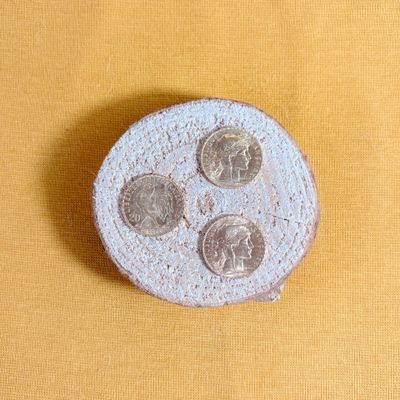 a small coin sitting on top of a yellow surface