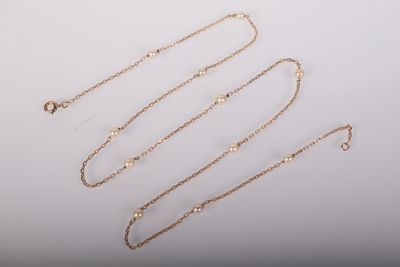 un ensemble de colliers et de bracelets en or posés sur une surface blanche