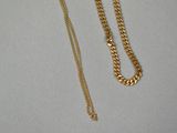 a close up of a gold necklace with a chain attached to it