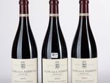 trois bouteilles de vin rouge posées sur une table