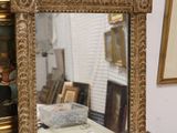 a mirror sitting on top of a table next to a painting
