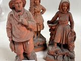 Plusieurs figurines représentant des personnes sont disposées sur une surface blanche