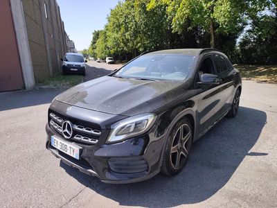 La Mercedes GLA est garée dans la rue, devant un immeuble.