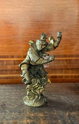 une statue représentant un homme à cheval posée sur une table en bois
