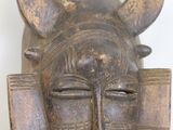 an image of a wooden mask with horns on a white background