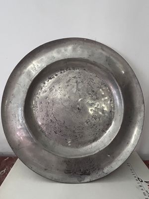 une assiette en argent posée sur un livre, sur une table