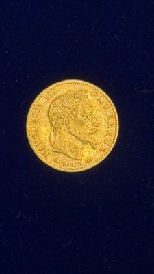 gros plan d'une pièce d'or sur une surface noire