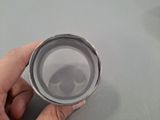 a person holding a silver cup on a table