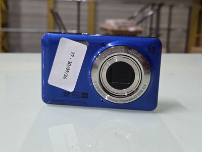 un appareil photo bleu posé sur une table, avec une étiquette de prix dessus
