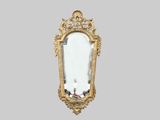 un miroir doré accroché au mur de la pièce