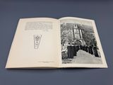 un livre ouvert sur lequel figure la photographie en noir et blanc d'un bâtiment
