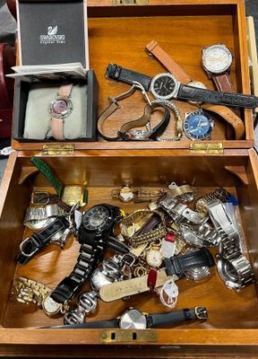 une boîte en bois remplie d'une sélection de montres et d'autres objets