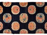 an image of a black rug with orange and blue flowers on it