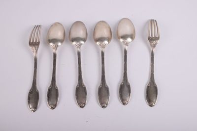 six cuillères et une fourchette sont alignées sur une surface blanche