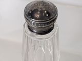 a glass salt and pepper shaker sitting on a counter