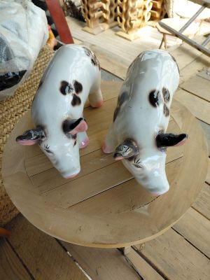 deux vaches en céramique posées sur un plateau en bois