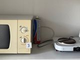 a microwave and a coffee maker sitting on a shelf