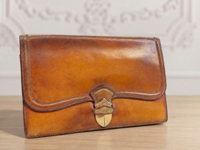 un sac à main en cuir marron posé sur une table en bois