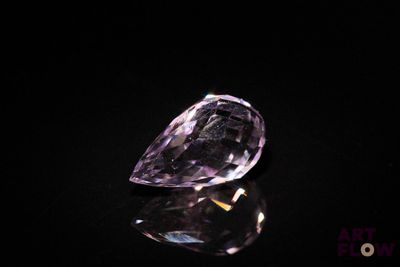 a close up of a purple diamond on a black surface