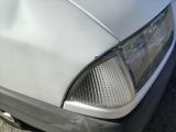 a close up of a white car with a dent in the front of it