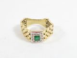 gros plan d'une bague en or avec une pierre verte