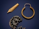 two gold and diamond earrings, a pen, and a piece of jewelry