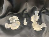 trois oiseaux en verre transparent posés sur un tissu noir