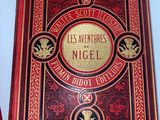 an old red book with a gold and black cover on a white surface