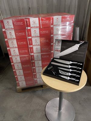 une boîte de couteaux posée sur une table, à côté d'une pile de boîtes