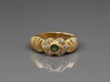 a close up of a gold ring with a green and white stone