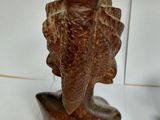 a wooden sculpture of a woman on a table